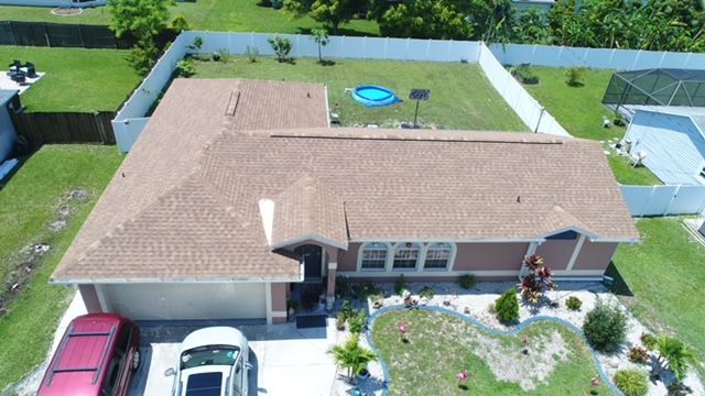 An aerial view of a house with a red van parked in front of it.