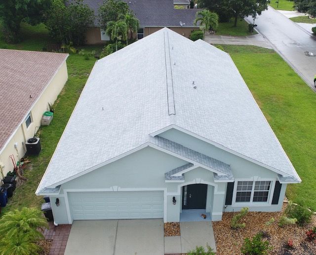 An aerial view of a house with a white roof