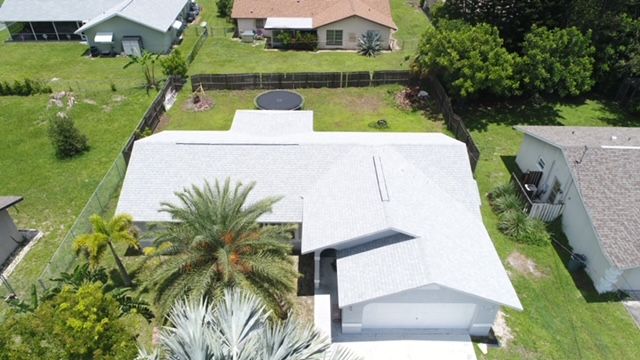 An aerial view of a house with a white roof
