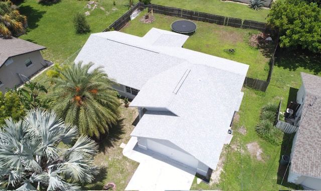 An aerial view of a house with a palm tree in front of it.