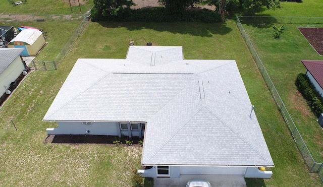 An aerial view of a house with a white roof.