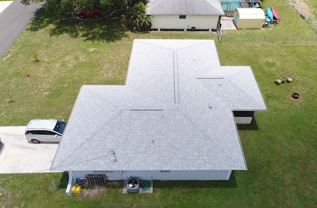 An aerial view of a house with a white van parked in front of it.