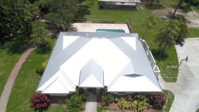 An aerial view of a house with a white roof