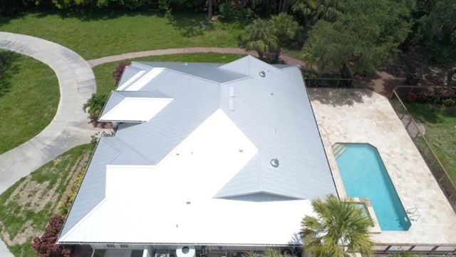An aerial view of a house with a pool in the backyard.