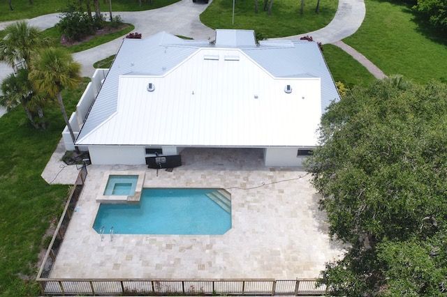 An aerial view of a house with a large swimming pool