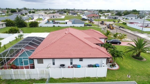 An aerial view of a house with a red tile roof