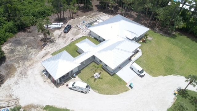 An aerial view of a house with a lot of cars parked in front of it.
