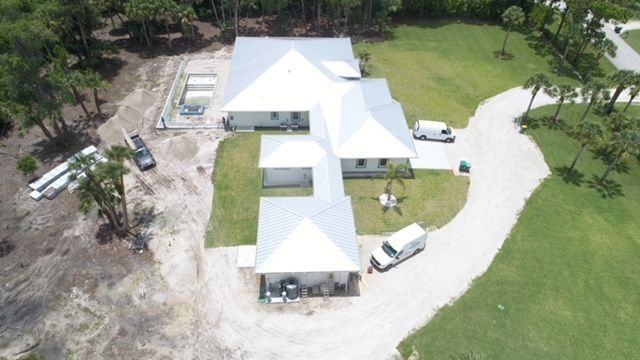 An aerial view of a house with a white roof