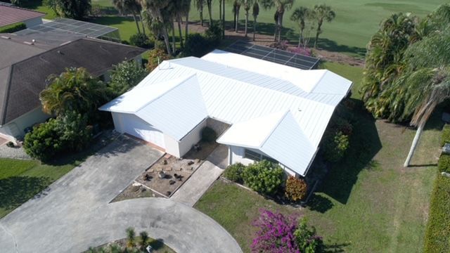 An aerial view of a house with a white roof
