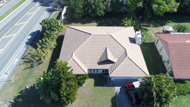 An aerial view of a house with a car parked in front of it