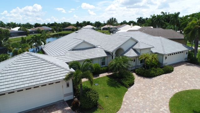 An aerial view of a large white house with a tile roof.