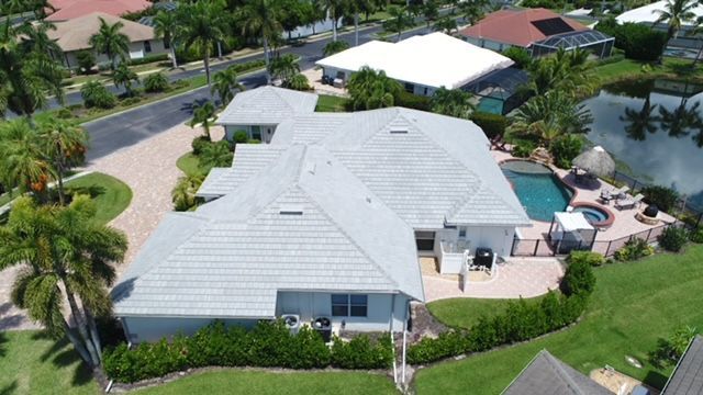 An aerial view of a house with a pool and palm trees