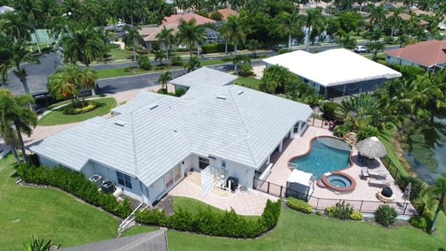 An aerial view of a house with a pool in a residential area.