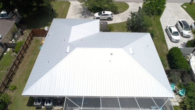 An aerial view of a house with a white roof