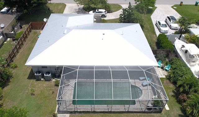An aerial view of a house with a screened in pool.