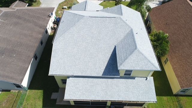 An aerial view of a house with a gray roof