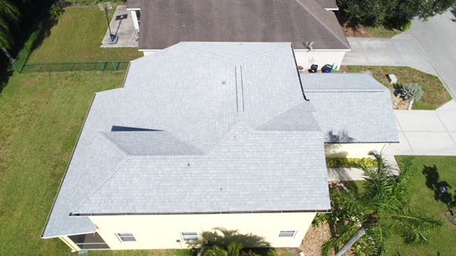 An aerial view of a house with a gray roof