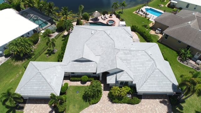 An aerial view of a large house with a pool in the backyard.
