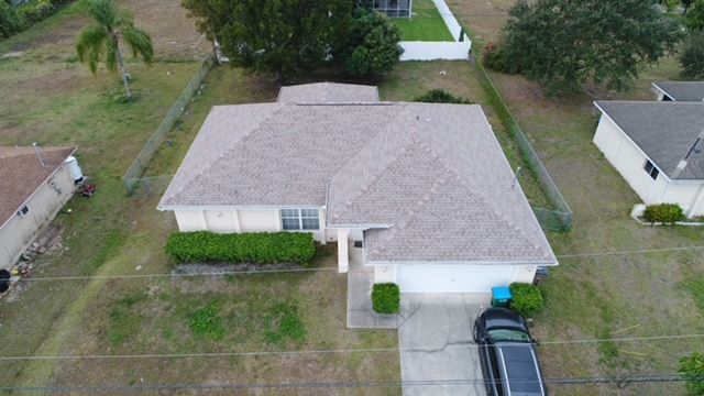 An aerial view of a house with a car parked in front of it.