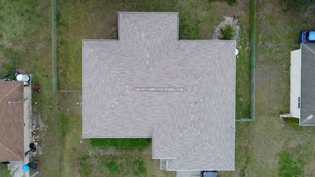 An aerial view of a house with a roof that looks like a cross.