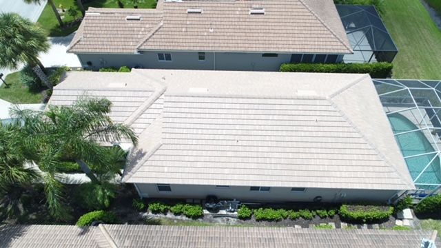 An aerial view of a house with a tiled roof and a pool.