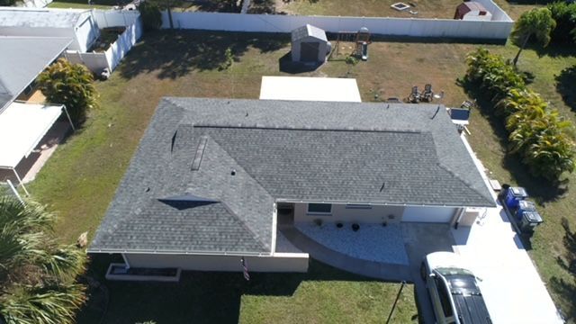 An aerial view of a house with a gray roof