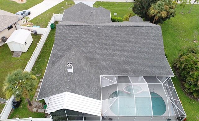 An aerial view of a house with a pool and a roof.