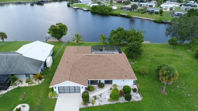 An aerial view of a house next to a body of water.