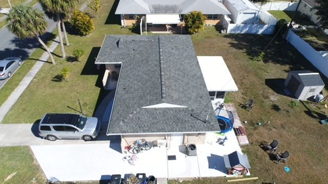 An aerial view of a house with a car parked in front of it