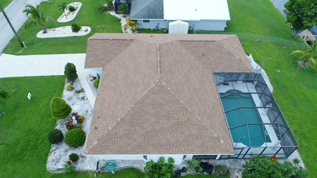 An aerial view of a house with a pool and a roof.