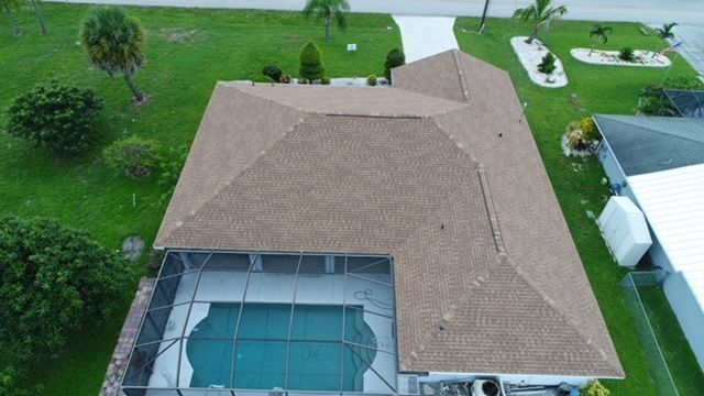 An aerial view of a house with a pool and a roof.