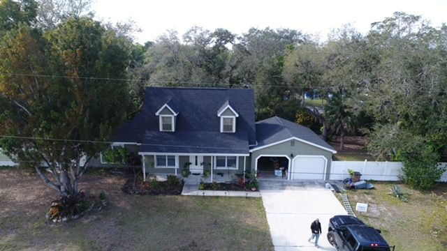 An aerial view of a house with a car parked in front of it.