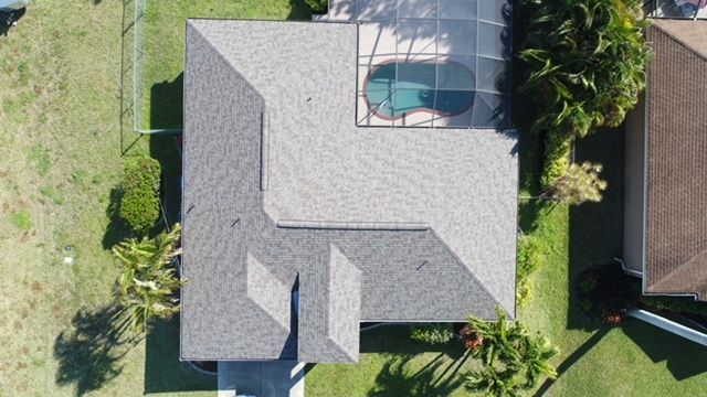 An aerial view of a house with a pool in the backyard.