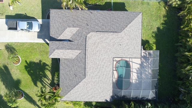 An aerial view of a house with a pool and a car parked in front of it.