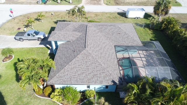 An aerial view of a house with a pool and a truck parked in front of it.