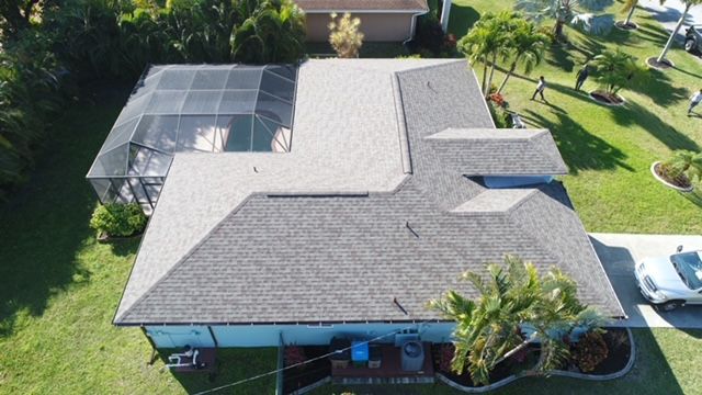 An aerial view of a house with a roof and a pool.