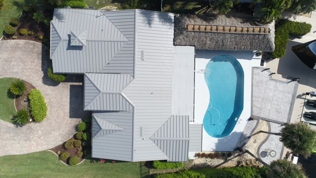 An aerial view of a large house with a pool in the backyard.