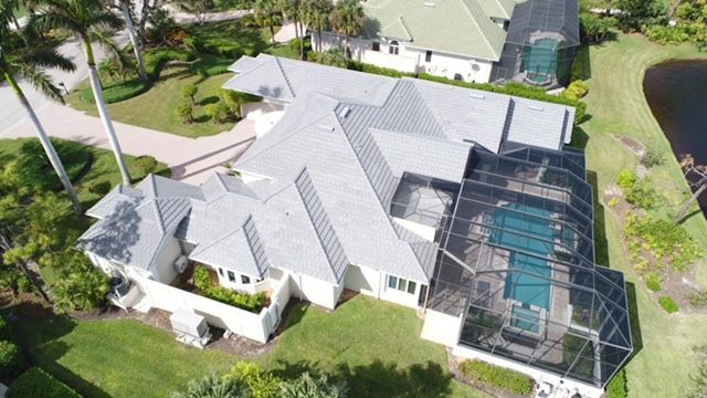 An aerial view of a house with a pool and a screened in porch.