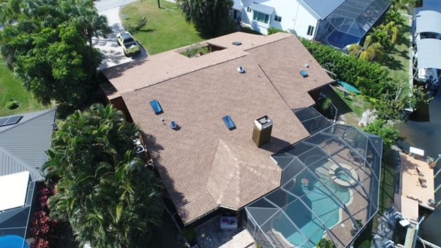 An aerial view of a house with a pool in the backyard.