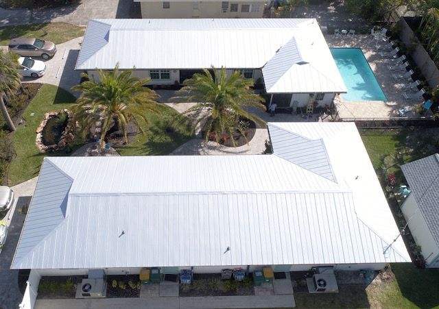 An aerial view of a row of houses with a pool in the background.