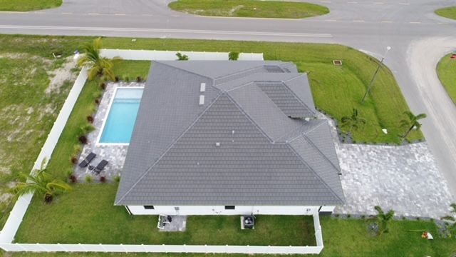 An aerial view of a house with a pool in the backyard.