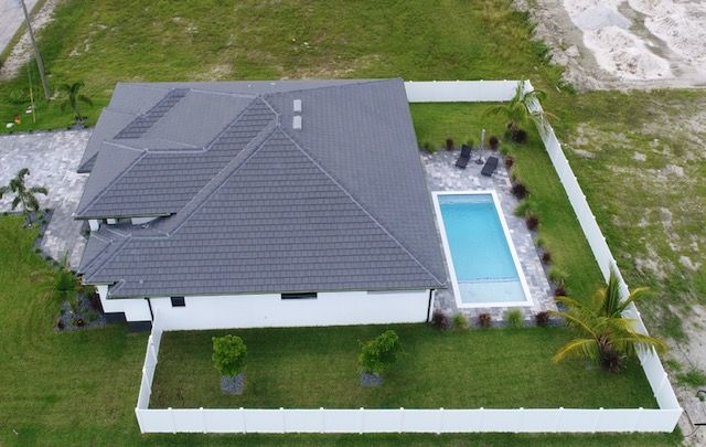 An aerial view of a house with a pool in the backyard.