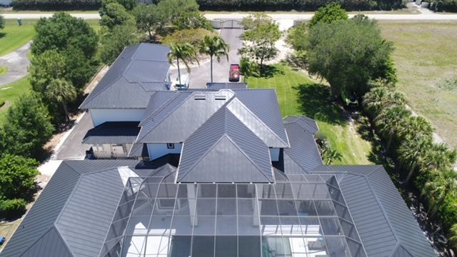 An aerial view of a large house with a screened in pool.