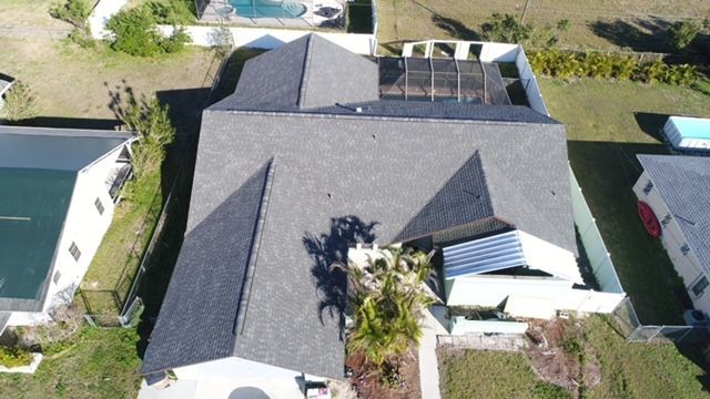 An aerial view of a house with a pool in the backyard