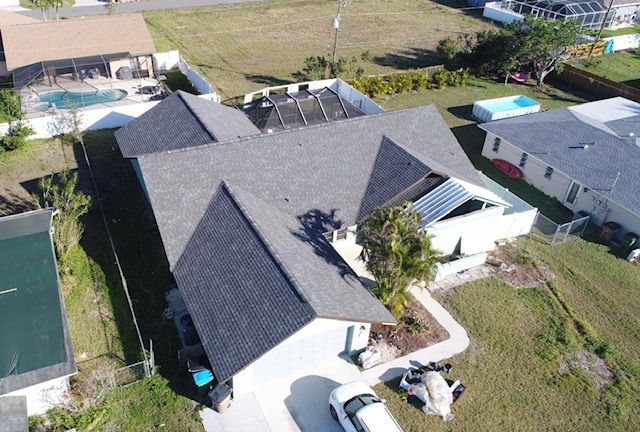 An aerial view of a house with a black roof