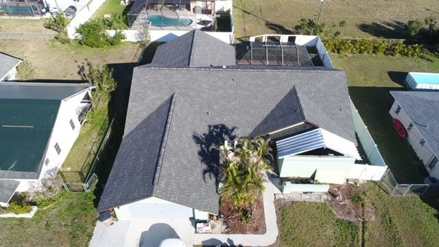 An aerial view of a house with a gray roof