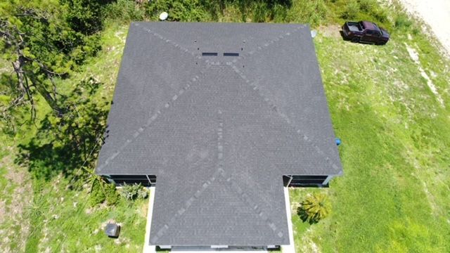 An aerial view of a house with a black truck parked in front of it.
