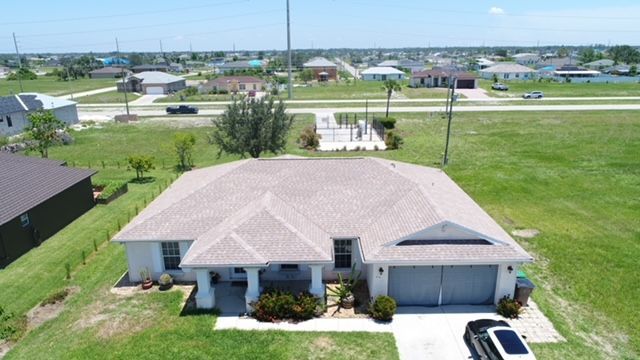 An aerial view of a house with a car parked in front of it.