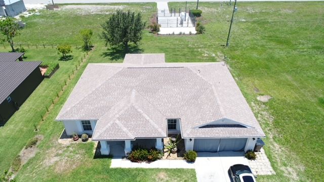 An aerial view of a house with a car parked in front of it.