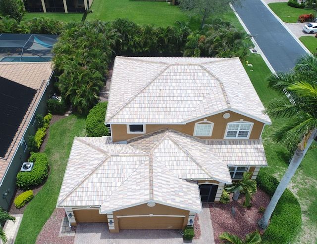 An aerial view of a house with a white tile roof